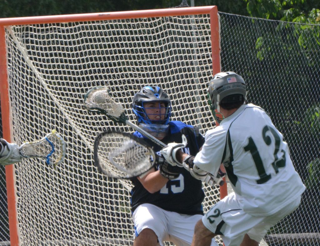 A lacrosse player is trying to block the ball.
