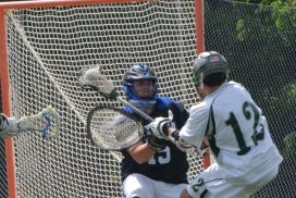 A lacrosse player is trying to block the ball.