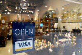 A sign that says open visa in front of a store window.