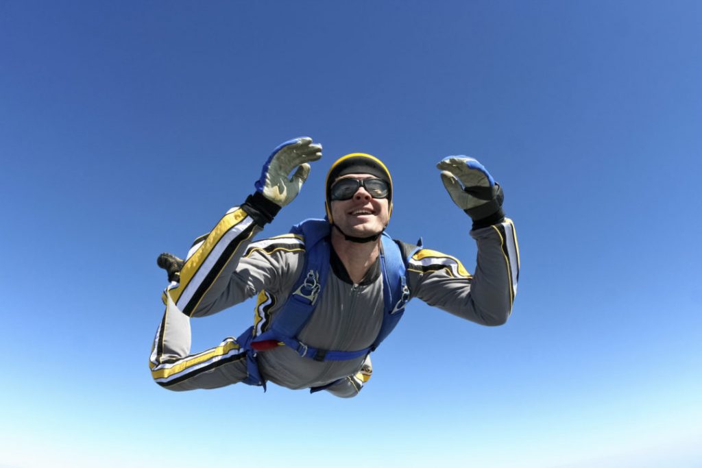A man in the air with his hands up.