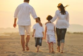 A family walking on the beach at sunset