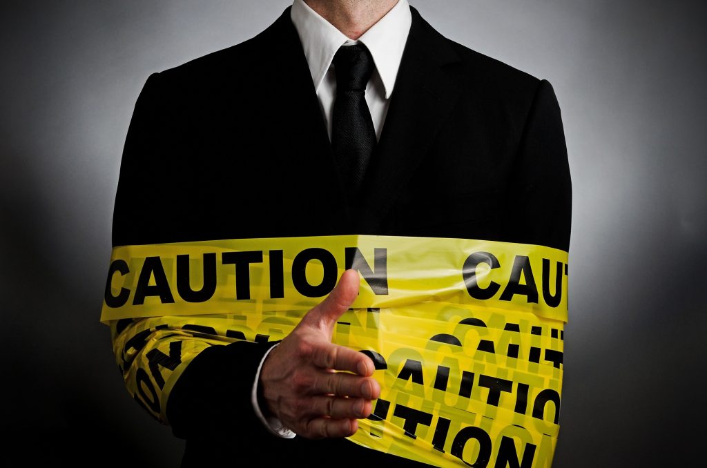 A man in suit and tie wrapped around caution tape.