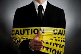 A man in suit and tie wrapped around caution tape.